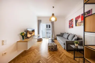 a living room with a couch and a tv at Kolonaki Square Executive Apartment in Athens