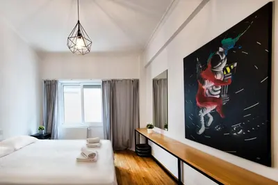 a bedroom with a bed and a large painting on the wall at Kolonaki Square Executive Apartment in Athens