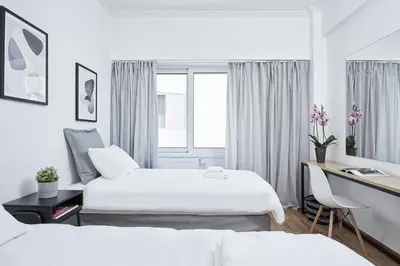 a hotel room with two beds and a desk at Kolonaki Square Executive Apartment in Athens