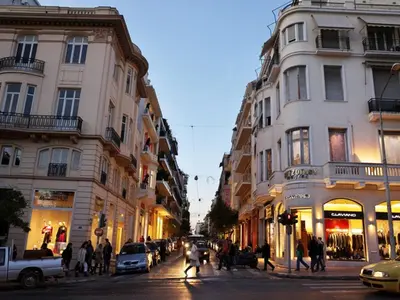 a city street with buildings and people crossing the street at Kolonaki Square Executive Apartment in Athens