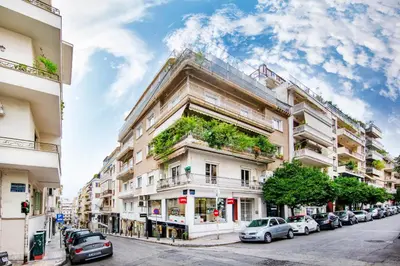a tall building with cars parked on a street at Kolonaki Square Executive Apartment in Athens