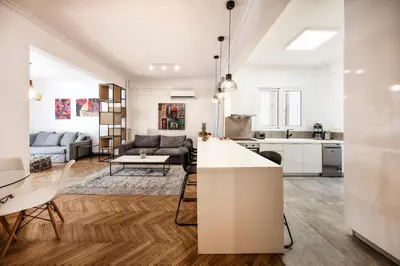 a kitchen and living room with white walls and wooden floors at Kolonaki Square Executive Apartment in Athens