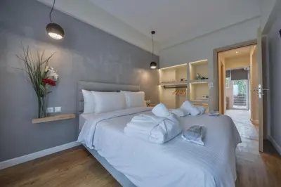 a bedroom with a large white bed with white pillows at A.P. Acropolis View Apartments in Athens