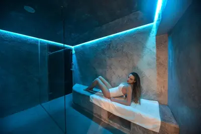 a woman laying in a tub in a room with blue lights at A.P. Acropolis View Apartments in Athens