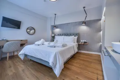 a bedroom with a bed and a desk and a sink at A.P. Acropolis View Apartments in Athens