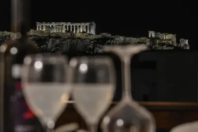 two glasses of wine in front of the acropolis at A.P. Acropolis View Apartments in Athens