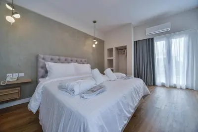 a bedroom with a large bed with white sheets at A.P. Acropolis View Apartments in Athens