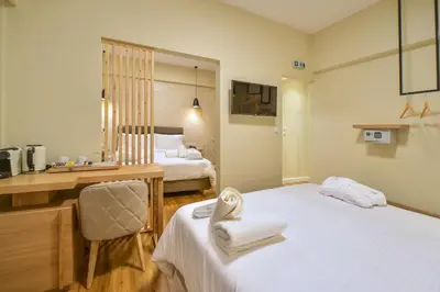 a hotel room with two beds and a desk at A.P. Acropolis View Apartments in Athens