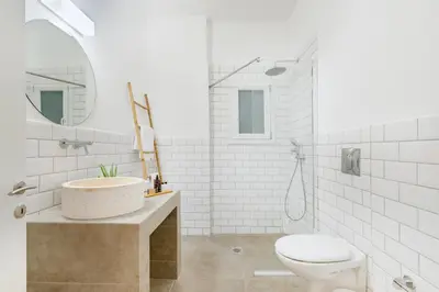 a white bathroom with a sink and a toilet at Maryflower Premium Apartments Piraeus in Piraeus