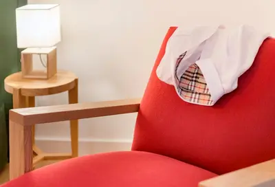 a red chair with a shirt and tie on it at Maryflower Premium Apartments Piraeus in Piraeus