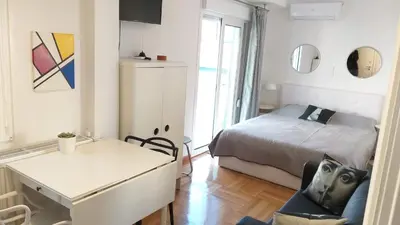a bedroom with a bed and a desk with a chair at The Cactus Apartment with Large Sunny Balcony in Athens