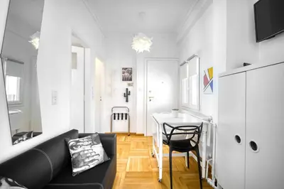 a living room with a black couch and a table at The Cactus Apartment with Large Sunny Balcony in Athens