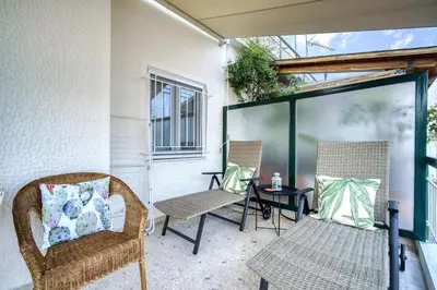 a patio with two chairs and a table at The Cactus Apartment with Large Sunny Balcony in Athens