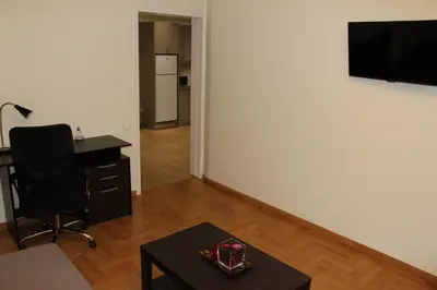 a living room with a desk and a chair and a television at Comfortable apartment in the center of Athens in Athens