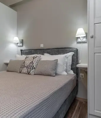 a bedroom with a large bed with two lamps at Αbsolute Athens VIII in Athens