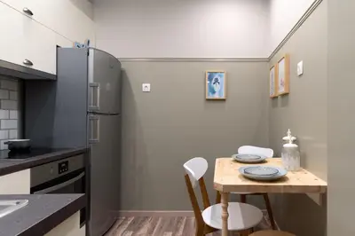 a kitchen with a small table and a refrigerator at Αbsolute Athens VIII in Athens