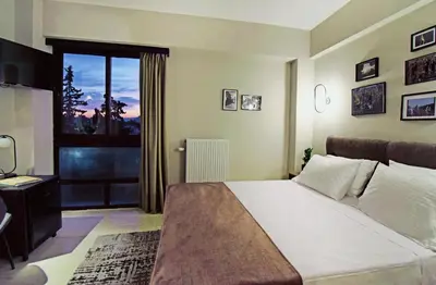 a bedroom with a large bed and a window at Athens Iris Hotel in Athens