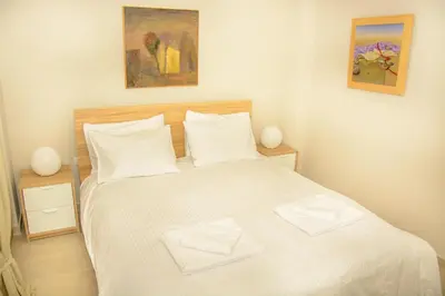 a bedroom with a white bed with two towels on it at Neighborly Nest - Apartment in the heart of Athens in Athens