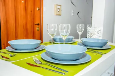 a table with bowls and plates and wine glasses at Neighborly Nest - Apartment in the heart of Athens in Athens