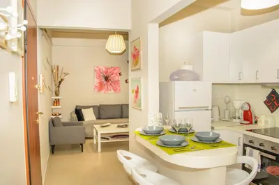 a kitchen and living room with a table and chairs at Neighborly Nest - Apartment in the heart of Athens in Athens