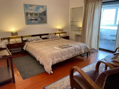 a bedroom with a large bed and a living room at Athens 360 penthouse, panoramic City view in Athens