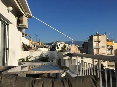 a balcony with a table and a view of a city at Sunkissed Rooftop Apartments in Athens