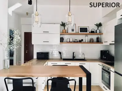 a kitchen with white cabinets and a wooden table at Sunkissed Rooftop Apartments in Athens