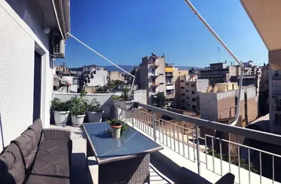 a balcony with a table and a view of a city at Sunkissed Rooftop Apartments in Athens