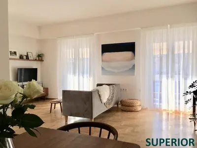 a living room with a chair and a table at Sunkissed Rooftop Apartments in Athens