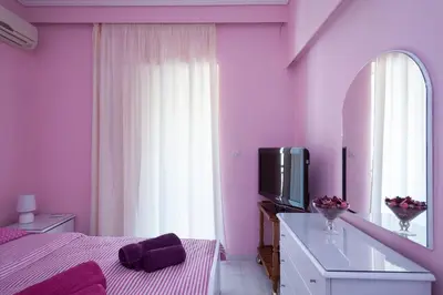 a pink bedroom with a bed and a tv at Elegant Athenian Apartment in Athens