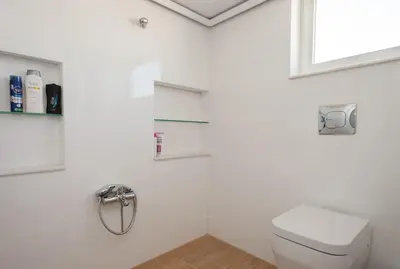a white bathroom with a toilet and a window at Elegant Athenian Apartment in Athens