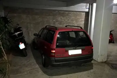 a red car parked in a garage next to a motorcycle at Elegant Athenian Apartment in Athens