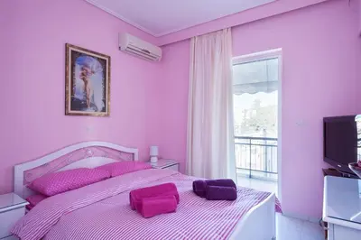 a bedroom with pink walls and a bed with purple pillows at Elegant Athenian Apartment in Athens