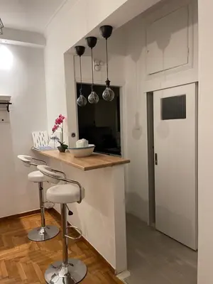 a kitchen with a counter and a bar with stools at Acropolis Exceptional View in Athens