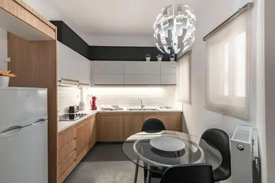 a kitchen with a glass table and black chairs at Athenian LInes, 50 meters from Acropolis Museum in Athens