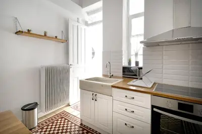 a kitchen with white cabinets and a sink and a window at Acropolis Memories in Athens