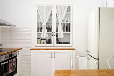 a kitchen with white cabinets and white appliances at Acropolis Memories in Athens