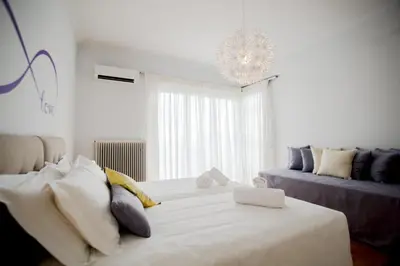 a bedroom with a large white bed and a couch at Bluscapes Home in Athens