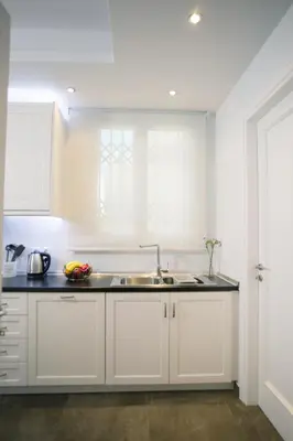 a kitchen with white cabinets and a sink at Bluscapes Home in Athens