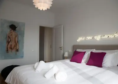 a bedroom with a large bed with purple and white pillows at Bluscapes Home in Athens
