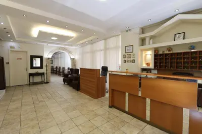 a lobby with a waiting room with desks and chairs at Athens Delta Hotel in Athens