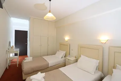 a hotel room with two beds and a table and lights at Athens Delta Hotel in Athens