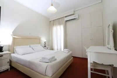 a white bedroom with a bed and a window at Athens Delta Hotel in Athens