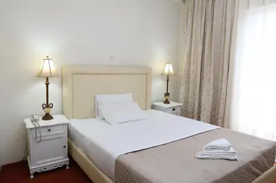 a bedroom with a large white bed with two lamps at Athens Delta Hotel in Athens