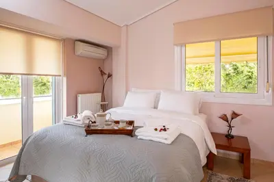 a bedroom with a large bed with towels on it at Nostalgia Seaview House in Anavissos