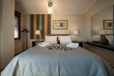 a bedroom with a large bed with flowers on it at Nostalgia Seaview House in Anavissos