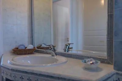 a bathroom counter with a sink and a mirror at Nostalgia Seaview House in Anavissos