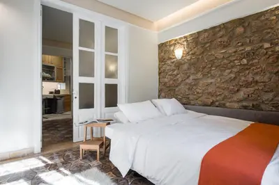 a bedroom with a large bed and a stone wall at Nest in Athens