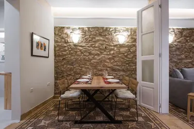a dining room with a table and a stone wall at Nest in Athens