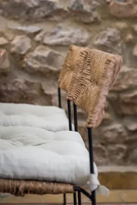 two wicker chairs sitting in front of a stone wall at Nest in Athens